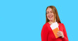 © Iryna - Young woman with suitcase and passport and boarding pass enjoys travel preparations against blue background