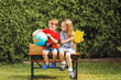 © Austockphoto - Boy and girl sitting together on desk outdoors
