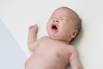 Wall Mural - Adorable newborn baby sneezing on soft mat