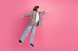 © deagreez - Young girl in casual outfit jumping joyfully on a vibrant pink background, expressing happiness and energy.