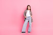 © deagreez - Stylish young girl in casual trendy outfit posing against a pink background, conveying charm, fashion, and youthful confidence.