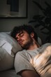 © StockUp - A young man sleeps on a soft pillow, illuminated by gentle sunlight, creating a serene atmosphere.
