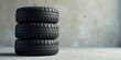 © yut - Stack of Three Used Vehicle Tires Against a Neutral Background