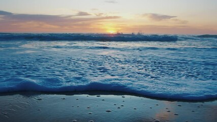 Wall Mural - Sandy beach at sunrise with sun and clam waves