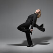 © Rytis - Fashion and lifestyle concept. Beautiful young woman with tailcoat suit studio portrait. Model making moves on gray background with copy space