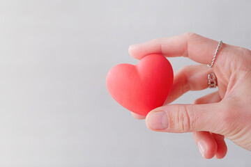 female hands holding small red heart shape