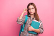 © deagreez - Young girl with glasses and books in a checkered shirt on a pink background showcasing a stylish casual look