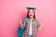 © deagreez - Young girl balancing books on head in stylish outfit against pink background