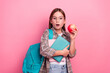 © deagreez - Adorable schoolgirl with books and apple on pink background showcasing back-to-school style