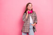 © deagreez - Charming young girl with pink headphones posing against a vibrant pink background, dressed in stylish casual attire with a checkered shirt.