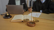 © Krakenimages.com - Man and woman in a law office discussing a legal matter with a scale of justice, gavel, and open book on the table