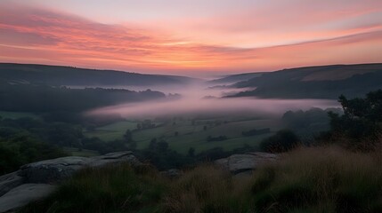 Wall Mural - scenic hilltop view overlooking a misty valley at sunrise, with soft pink and orange hues in the sky