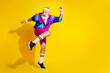 © deagreez - Full length photo of handsome good mood senior guy oldschool sportswear dancing emtpy space isolated yellow color background