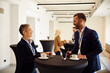 © Boris Jovanovic/Stocksy - Colleagues chat at a standing desk