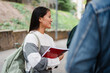 © Nuria Seguí/Stocksy - Happy Female Student Listening To Friends At Campus