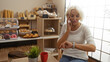 © Krakenimages.com - Woman talking on phone, checking time in bakery with various pastries showcased indoors
