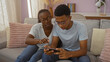 © Krakenimages.com - Mother and son spending quality time together in the living room, engaging with a smartphone while seated on a comfortable sofa, showcasing a loving family bond in a warm, indoor setting