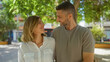 © Krakenimages.com - Couple smiling in an outdoor, park setting, a man and woman look at each other affectionately during a sunny day in the urban area