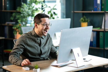 Funny excited surprised man in glasses looking at screen of laptop computer device. Happy lucky guy gets job offer business email, wins a cool prize or earns easy money on gaming website