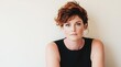 © Eva - Confident middle aged woman with curly hair poses against a neutral background in a stylish black outfit