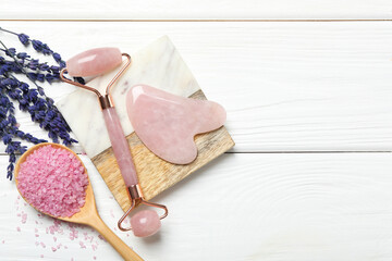 Wall Mural - Face roller, gua sha tool, sea salt and lavender flowers on white wooden background, flat lay. Space for text