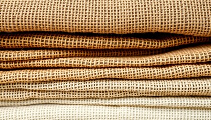 Sustainable textile collection close-up showing natural fiber weave patterns and earthy color transitions in stacked formation, clothing fabric textures