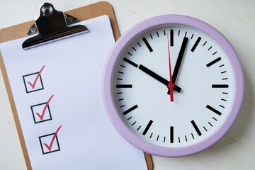 Leinwandbilder - A clipboard with a checklist and a clock emphasizes the importance of time management and task completion.