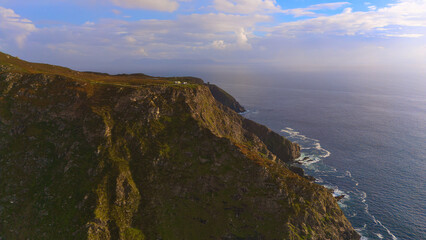 Wall Mural - Beautiful Ireland - A breathtaking view showcasing rocky cliffs meeting calm, gentle waters beneath a vast, clear blue sky