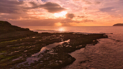 Wall Mural - Muckcross Head Donegal Ireland - The breathtaking view of the vast ocean at sunset showcases captivating and colorful cloud patterns