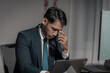 © MrAshi - Image of a young businessman experiencing stress late at night at work. Read financial reports and accounting documents, unhappy with results and disappointed with success.