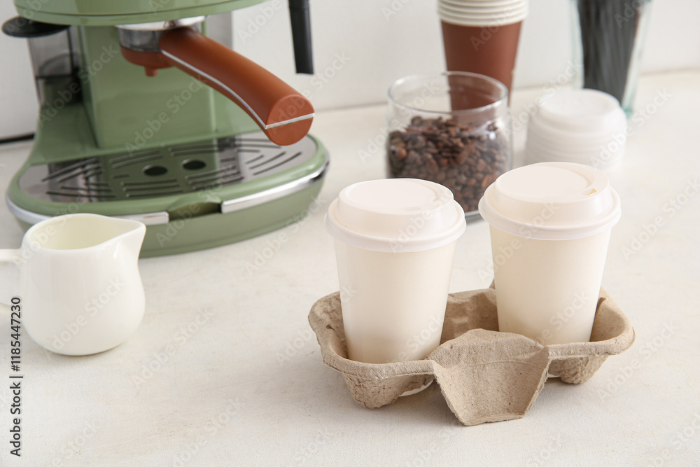 Holder with takeaway cups of hot coffee on white background