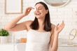 © Pixel-Shot - Happy young woman with cotton pad for removing makeup in bathroom