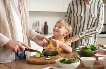 Wall Mural - Happy little boy with his parents cutting cucumber for Fajita in kitchen