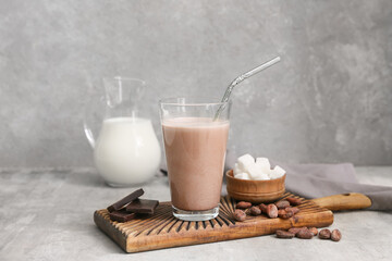 Sticker - Glass of sweet chocolate milk with cocoa beans and cubes of sugar on grey background