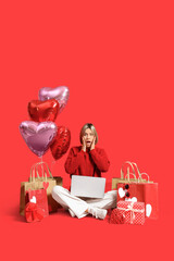 Wall Mural - Surprised young woman with laptop shopping online on red background. Valentine's Day celebration