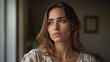 © Daniel L - A beautiful woman with a looking of concern or worry on her face. Floral top. Living room. Illuminated by natural window light.