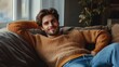 © The 2R Artificiality - Casual portrait of a stylish slim male model in a warm orange sweater and blue jeans, lounging comfortably on a cozy couch with natural light spilling in, creating a relaxed atmosphere, ideal for life
