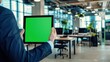 © Palugada - Businessman holding a tablet with green screen in the office. Business concept