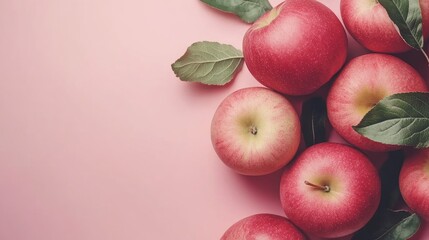 Canvas Print - Ripe red apples with green leaves arranged artistically on a soft pink background for fresh produce and seasonal themes