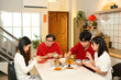 © Prathankarnpap - Happy asian family sharing meals and blessings with loved ones during Chinese New Year celebration