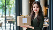 © S.JR Stocker - A young Asian female entrepreneur stands outside her upscale restaurant, proudly holding a neatly wrapped package with a blank label for mock-up purposes.