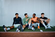 © Flamingo Images - Diverse group of fit young men in sportswear talking while sitting together on the floor of a gym after a workout class
