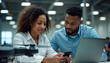 © miss irine - Two diverse tech professionals collaborate on drone tech project. Woman codes on laptop while colleague examines semiconductor. They are in modern factory lab. Collaborative teamwork in tech company.