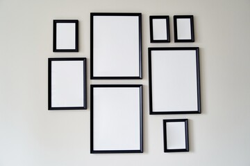 Different size framed photos hanging on the gray wall. High quality photo