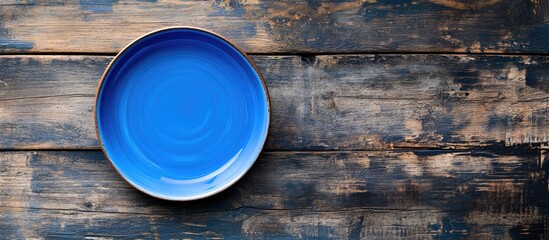Poster - blue plate on a wooden surface. with copy space image. Place for adding text or design