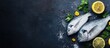© vxnaghiyev - Fresh raw sea bream fish dorado garnished with lemon slices herbs and parsley on a dark background Healthy food concept top view copyspace