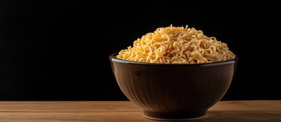 Poster - Raw instant noodles in a ceramic bowl on a wooden table with a dark black background This represents an easy quick and inexpensive food concept along with copyspace for adding text