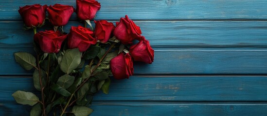 Wall Mural - red roses bouquet on blue wooden table top view. with copy space image. Place for adding text or design