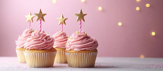 Poster - Golden star shaped candles on cupcakes with pink buttercream frosting Birthday cupcakes Party treats. with copy space image. Place for adding text or design