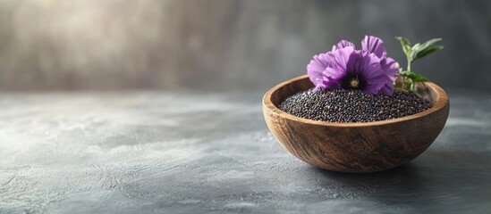Poster - Wooden bowl containing poppy seeds and a flower on a grey table room for text. with copy space image. Place for adding text or design